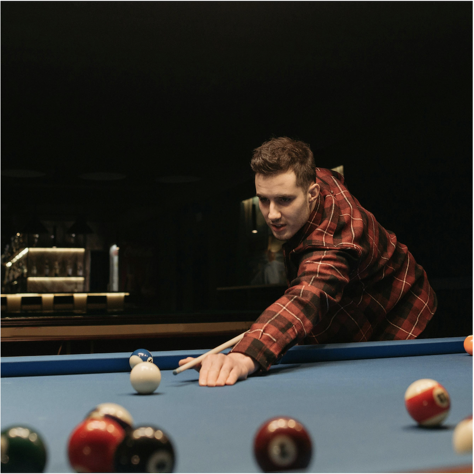 Man in a plaid shirt lining up a precise pool shot, illustrating the targeted approach of niche influencer marketing